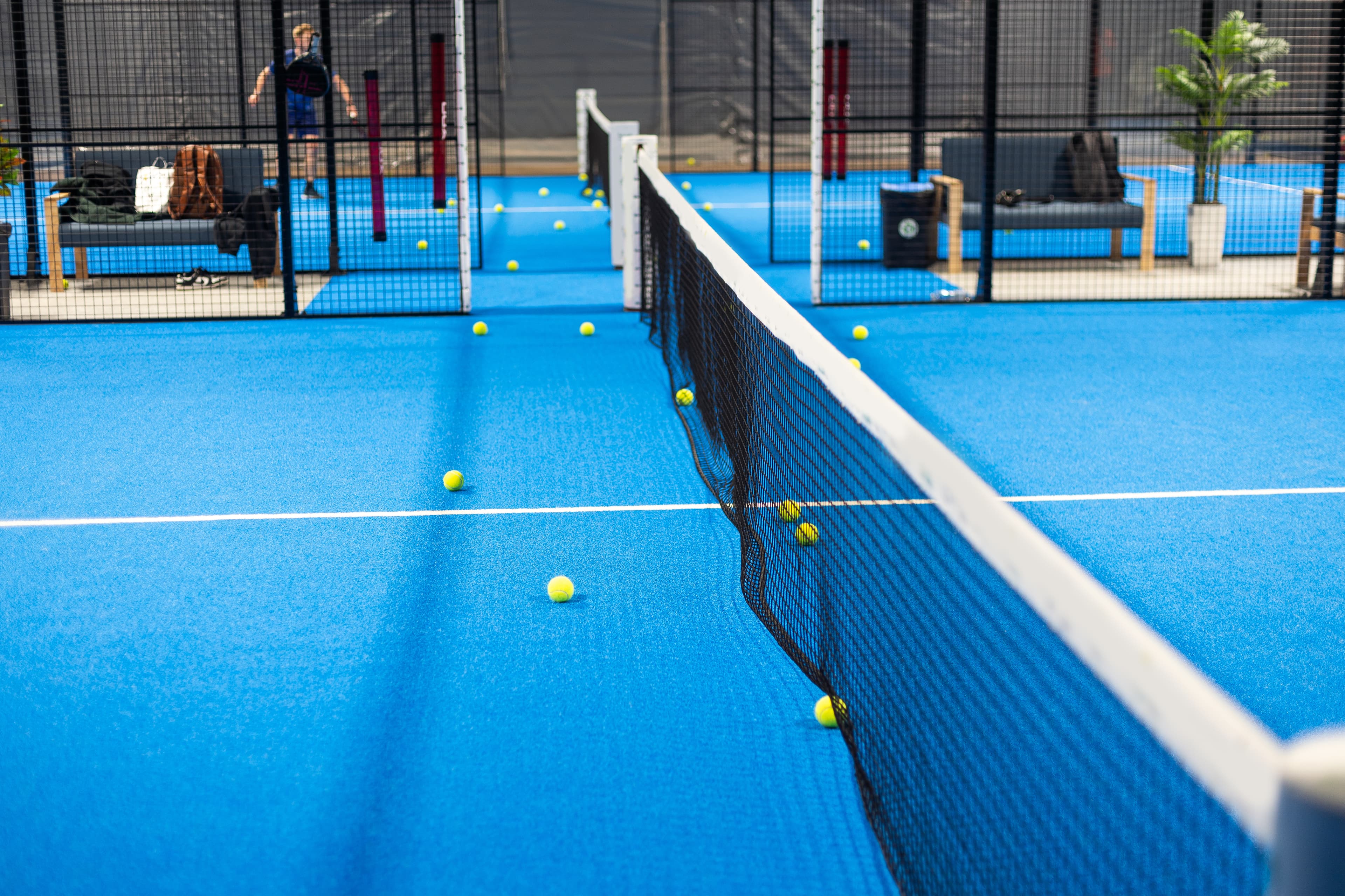 Padel racket resting on the net of a padel court